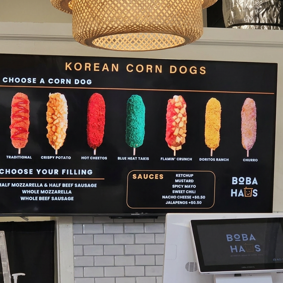 Boba Haus menu board displays colorful Korean corn dog options, fillings, sauces, and a touchscreen register at the counter.